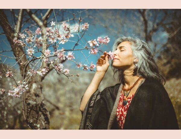Naslovnica za podcast kako voljeti sebe? Na slici je žena koja uživa u mirisu procvjetalog drveta.